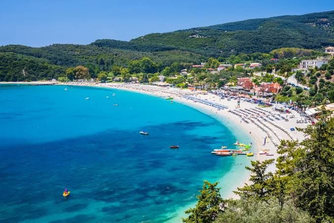 Valtos beach: a long curve of sand and sunbeds beside turquoise water